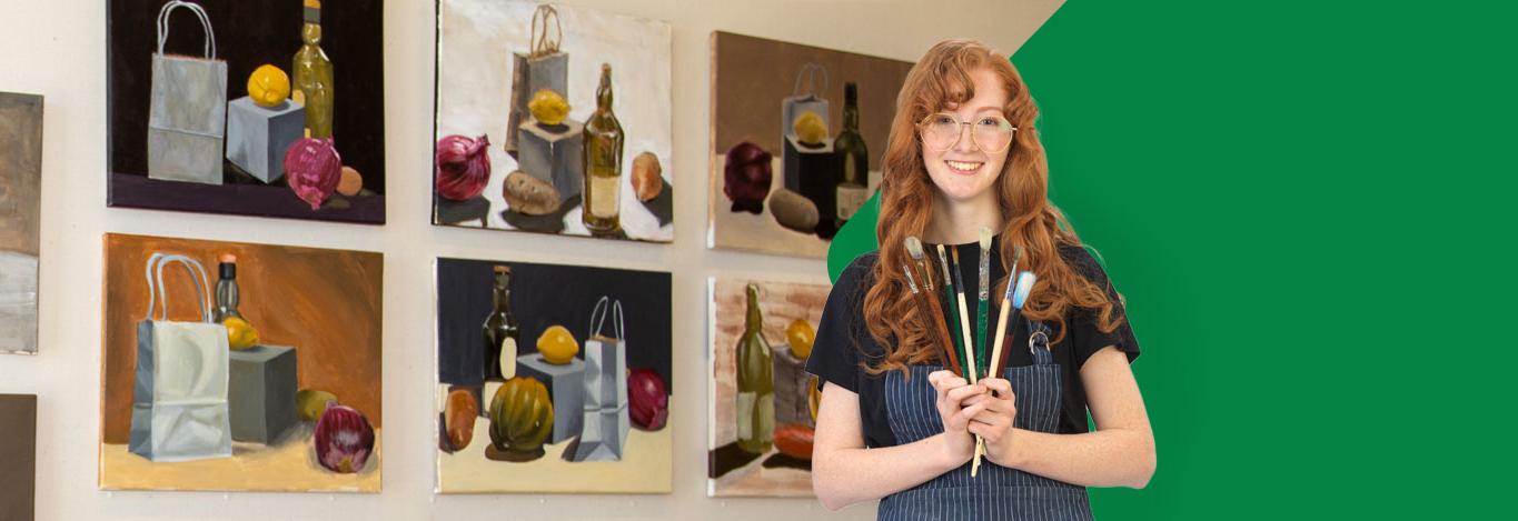 Student holding paintbrushes